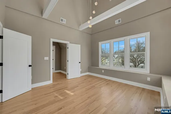 an empty room with wooden floor and a window