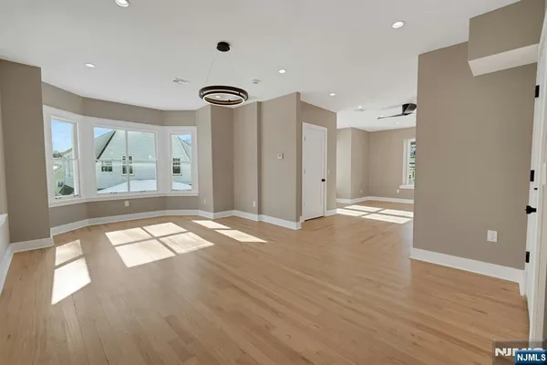 a view of empty room with wooden floor and window