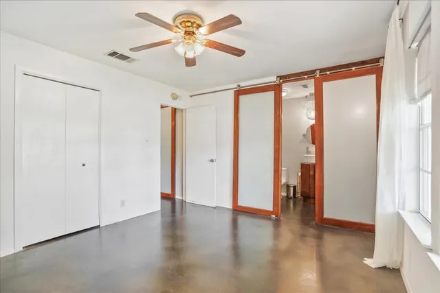 en empty room with windows and ceiling fan