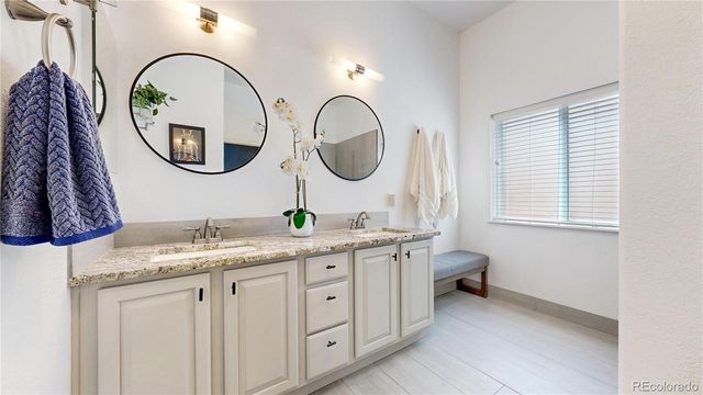 a bathroom with a granite countertop toilet a sink and a mirror