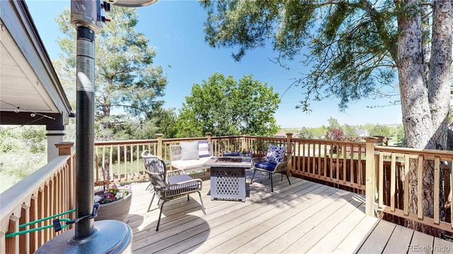 a view of balcony with wooden floor outdoor seating and yard in the back