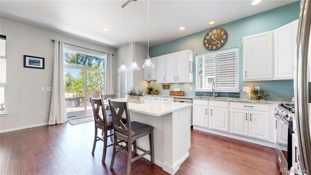 a kitchen with a table chairs cabinets and wooden floor