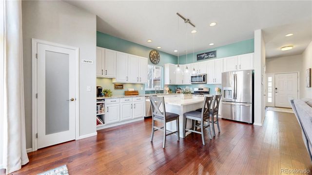 a kitchen with a refrigerator a white stove top oven and white cabinets