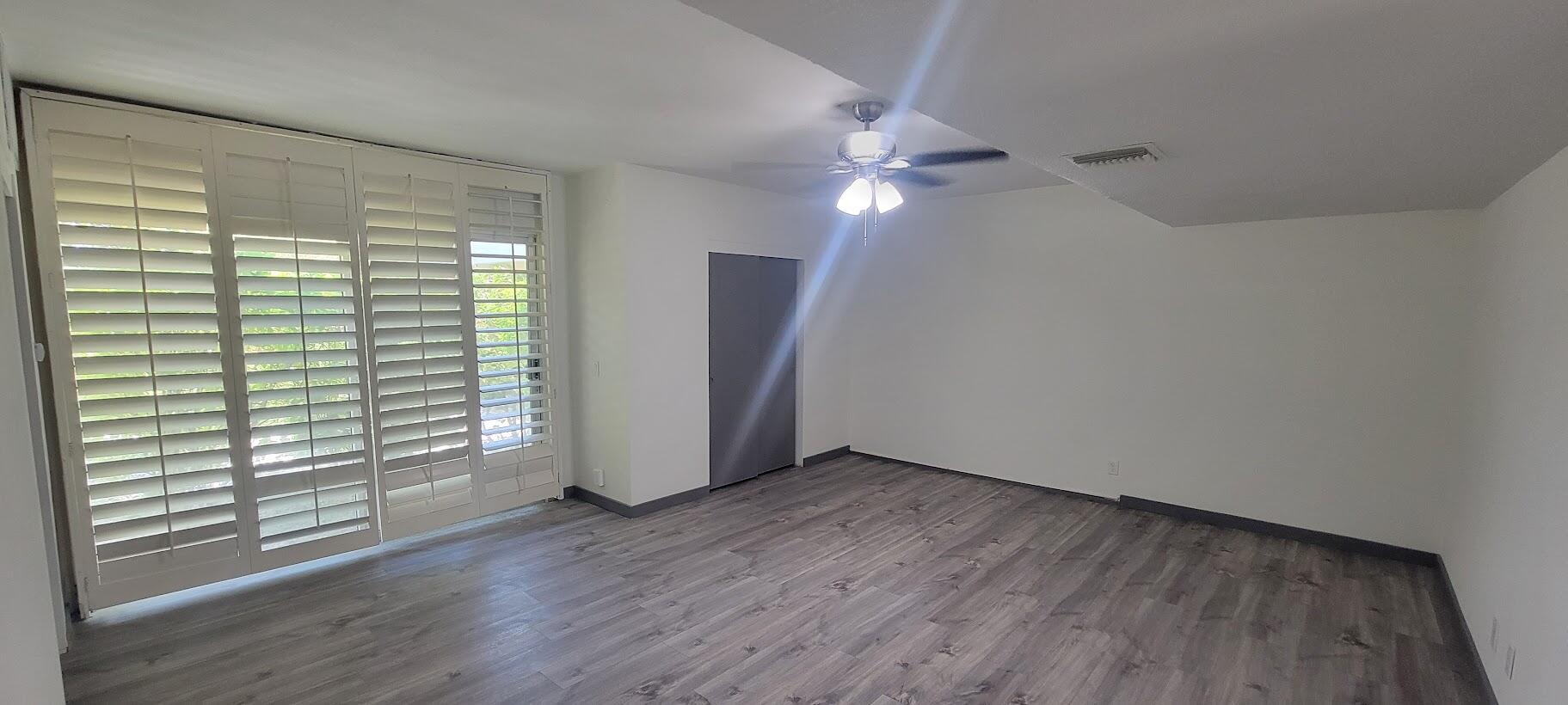 1855 Ramon Road, Unit 24 Palm Springs, CA 92264 - Photo 4 of 18 an empty room with wooden floor and windows