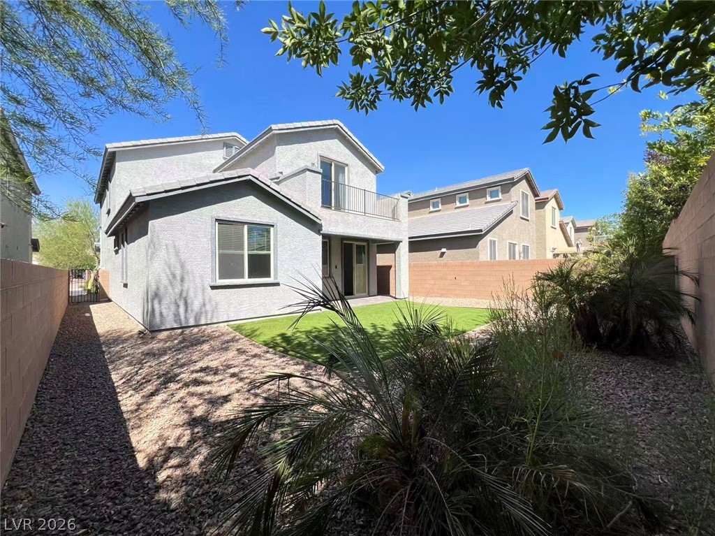 925 Bayberry Ridge Street Henderson, NV 89052 - Photo 26 of 27 A private backyard oasis features a manicured lawn and desert-friendly landscaping, perfect for outdoor enjoyment.