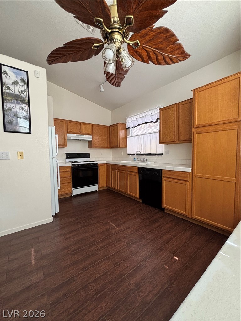 2661 Hillgrass Road Las Vegas, NV 89123 - Photo 11 of 27 Kitchen with a ceiling fan, vaulted ceiling, wood finish cabinets, stove, and dark wood-type flooring