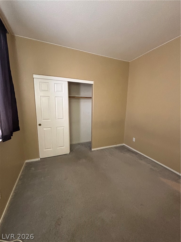 2661 Hillgrass Road Las Vegas, NV 89123 - Photo 16 of 27 Unfurnished bedroom featuring dark colored carpet and a closet
