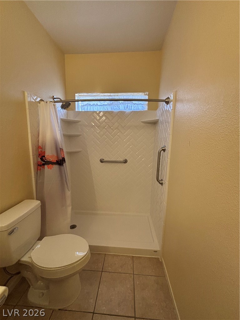 2661 Hillgrass Road Las Vegas, NV 89123 - Photo 19 of 27 Full bathroom with a shower stall, a textured wall, and light tile patterned floors