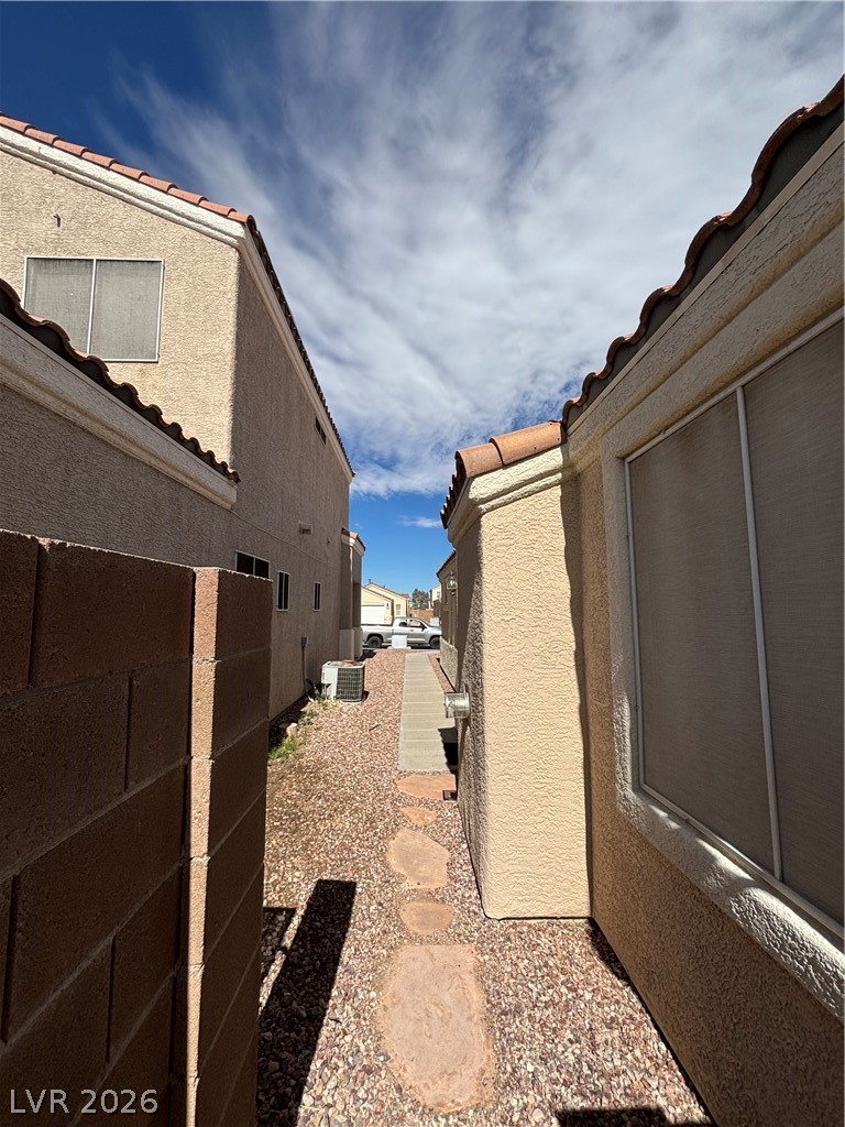 2661 Hillgrass Road Las Vegas, NV 89123 - Photo 27 of 27 View of side of property featuring a tiled roof and stucco siding