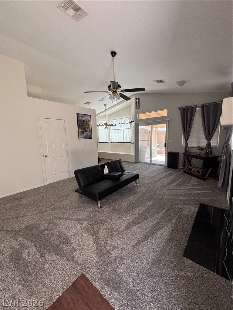 2661 Hillgrass Road Las Vegas, NV 89123 - Photo 3 of 27 Living area featuring lofted ceiling, a ceiling fan, and dark colored carpet