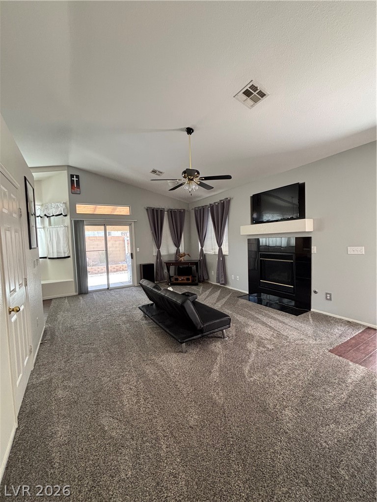 2661 Hillgrass Road Las Vegas, NV 89123 - Photo 6 of 27 Carpeted living room with a fireplace, vaulted ceiling, and a ceiling fan