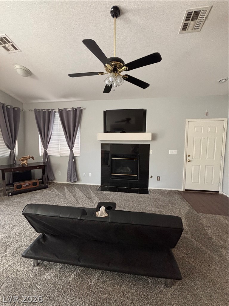 2661 Hillgrass Road Las Vegas, NV 89123 - Photo 7 of 27 Living area featuring a textured ceiling, carpet flooring, a tile fireplace, and a ceiling fan