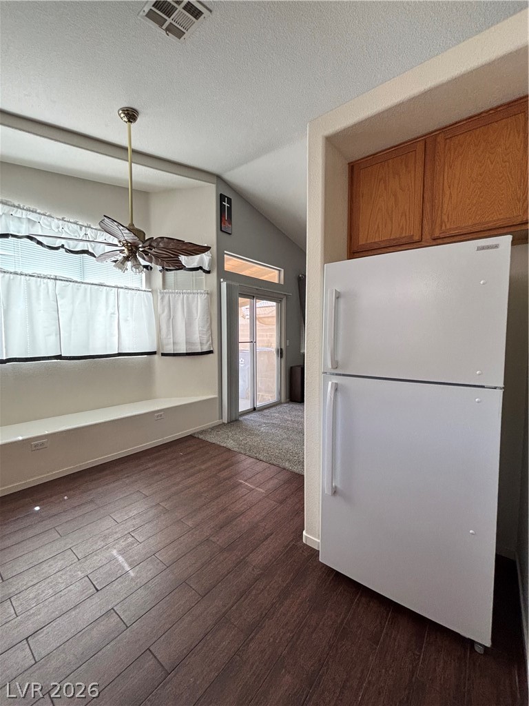 2661 Hillgrass Road Las Vegas, NV 89123 - Photo 9 of 27 Kitchen with fridge, dark wood-style floors, a ceiling fan, and wood finish cabinetry