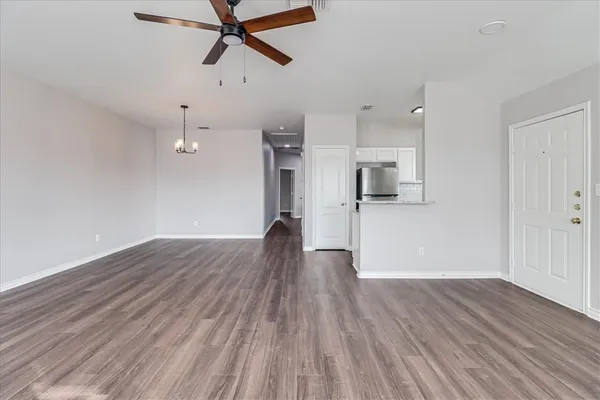 a view of empty room with wooden floor and window