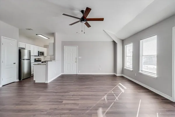 a view of empty room with wooden floor and window