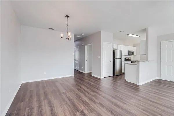 a view of a kitchen with wooden floor and a refrigerator
