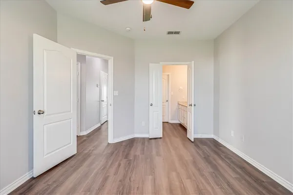 a view of a room with wooden floor a ceiling fan
