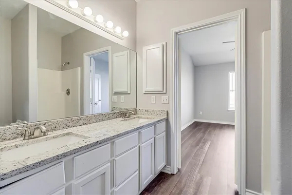 a bathroom with a granite countertop sink and a mirror