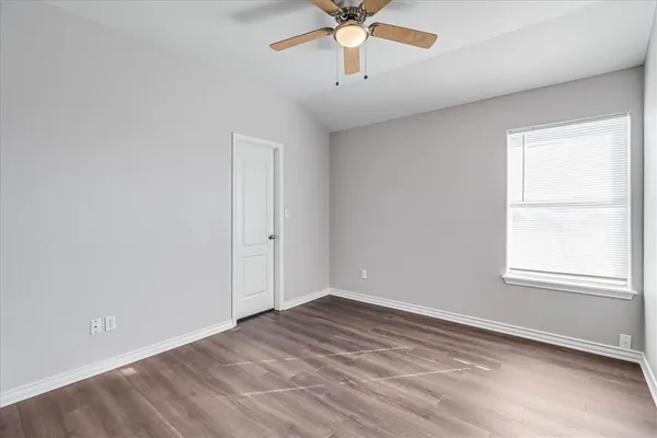 an empty room with a window and a fan