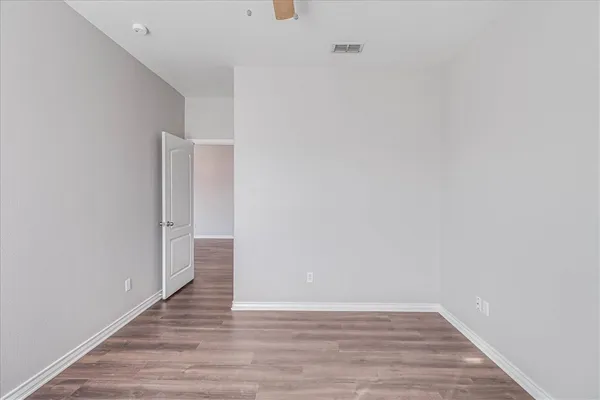 a view of an empty room with wooden floor