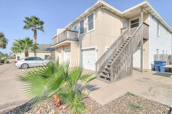 a view of a house with a yard and potted plants