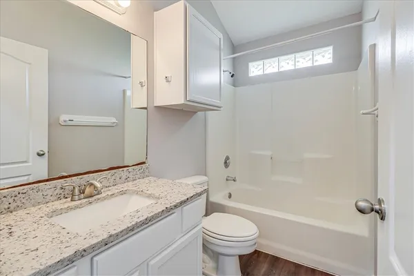 a bathroom with a granite countertop sink toilet and shower