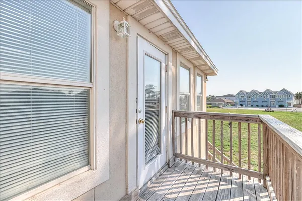 a view of a balcony with wooden floor and fence
