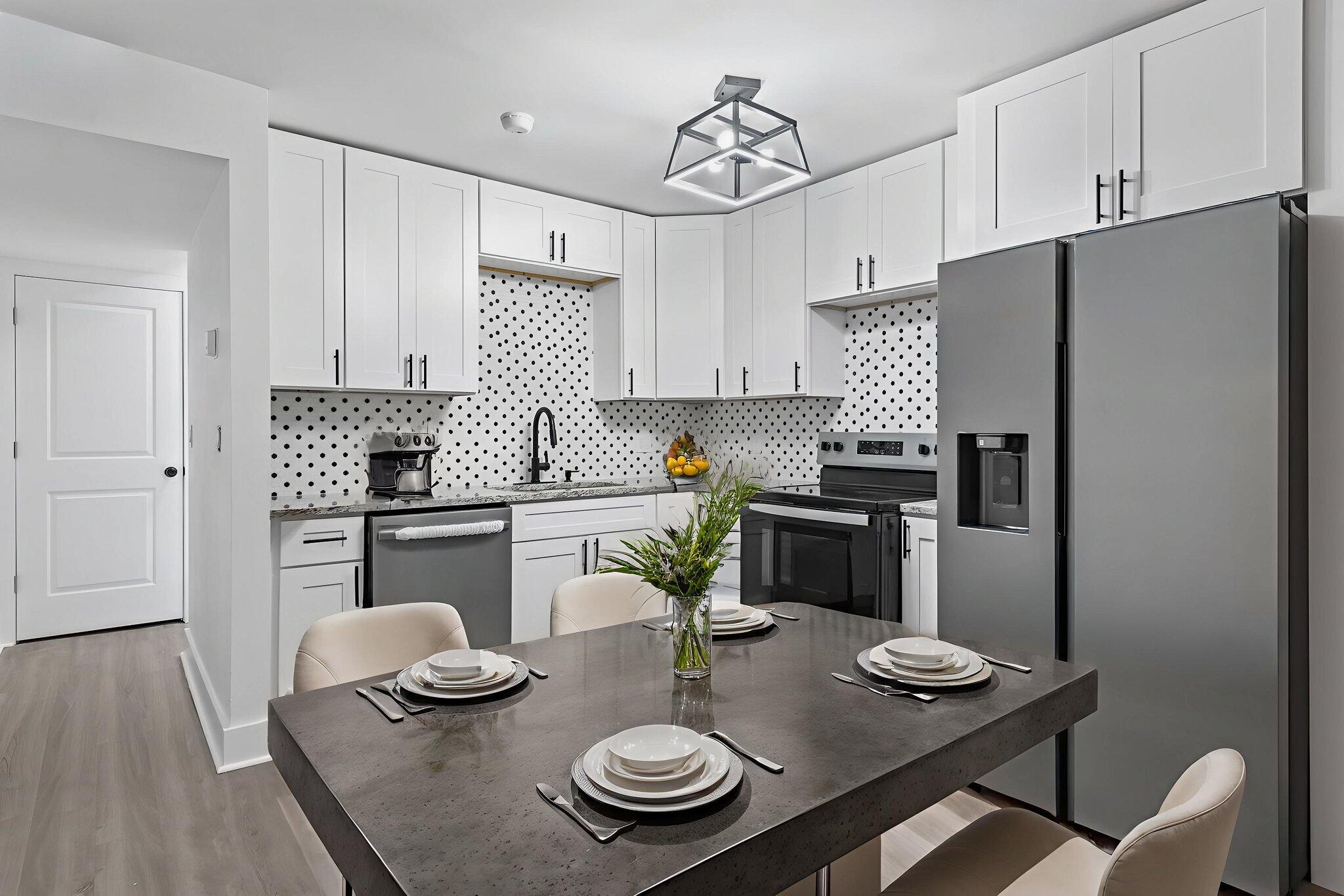 a kitchen with appliances a table and chairs in it