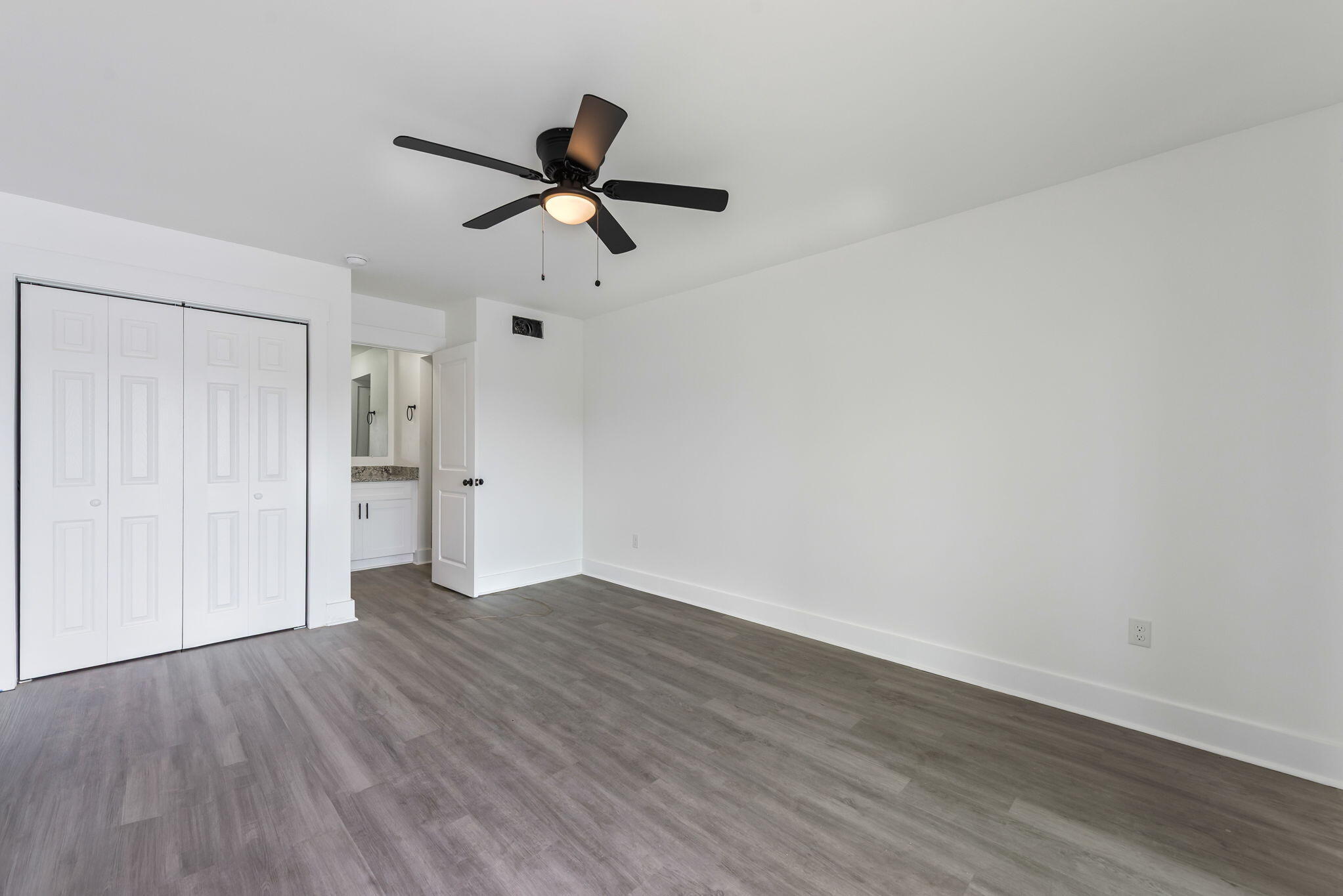 210 Pelham Road, Unit B107 Fort Walton Beach, FL 32547 - Photo 7 of 14 a view of a room with wooden floor and ceiling fan