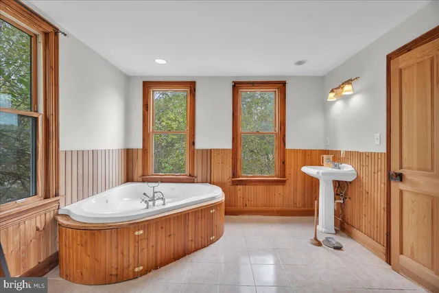a bathroom with a tub and large window