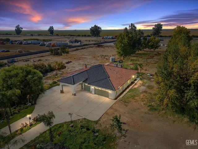 an aerial view of a house with a yard basket ball court and outdoor seating
