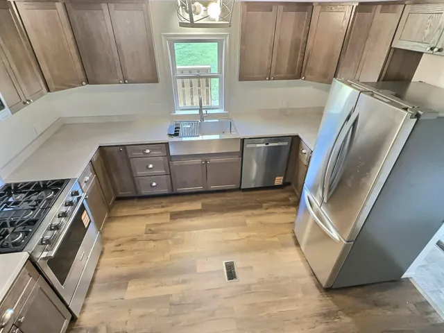 a kitchen with stainless steel appliances granite countertop a refrigerator and a stove