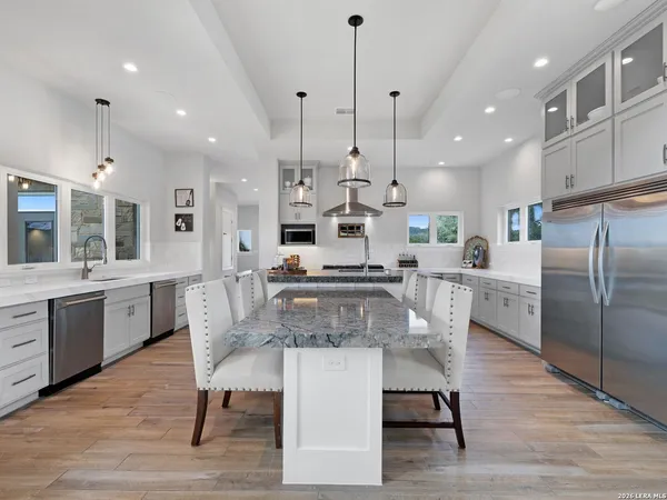 a kitchen with stainless steel appliances granite countertop a sink a stove top oven a counter space and cabinets