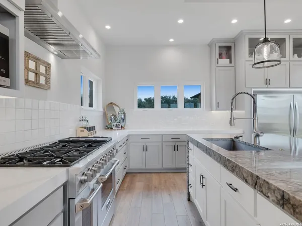 a kitchen with center island a counter space a sink appliances and cabinets