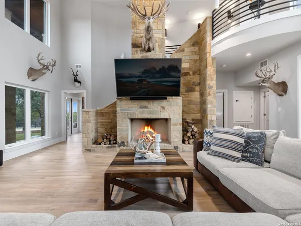 a living room with furniture kitchen view and a chandelier