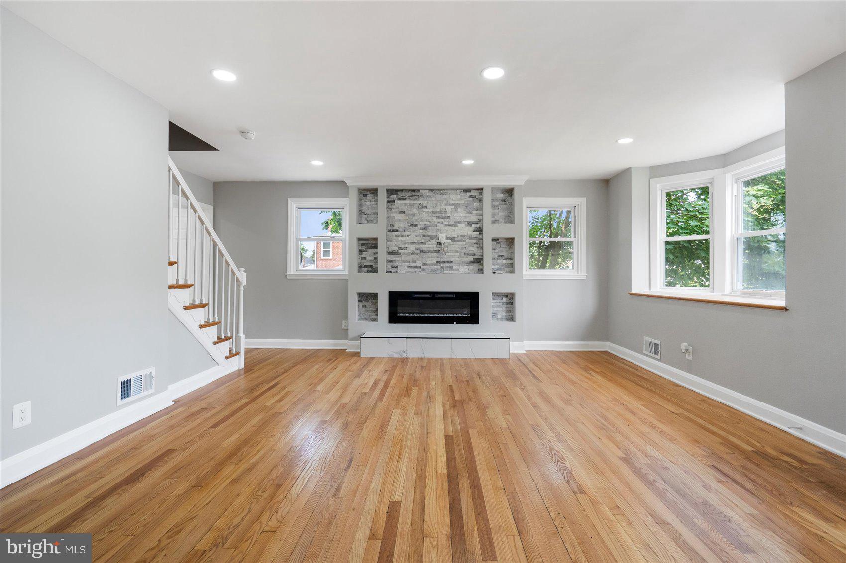 1601 Burnwood Road Baltimore, MD 21239 - Photo 5 of 46 a view of empty room with wooden floor and fireplace