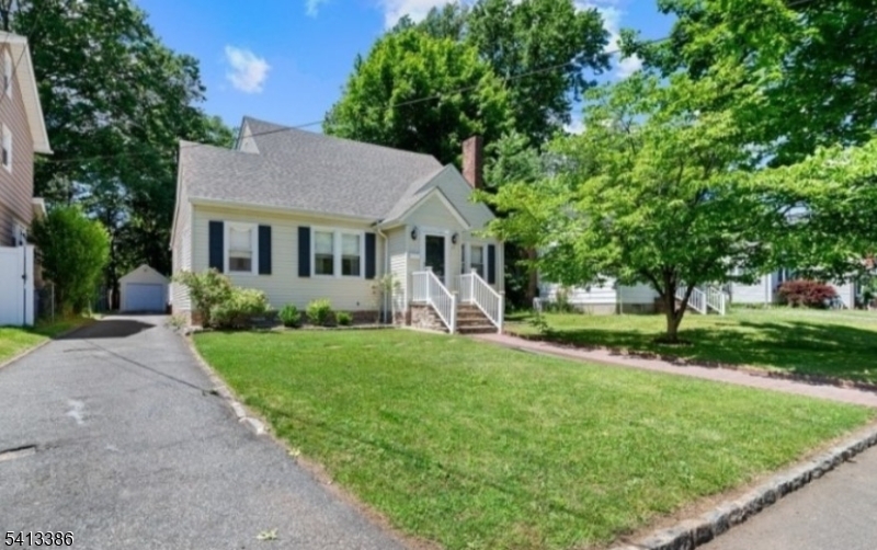 a front view of a house with yard and green space