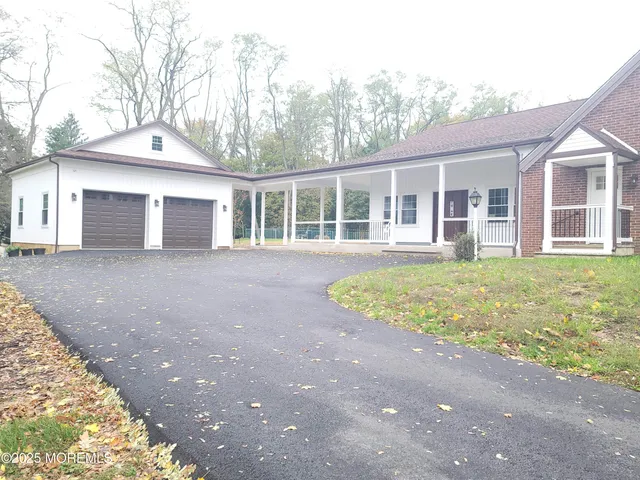 a front view of a house with a garden and trees