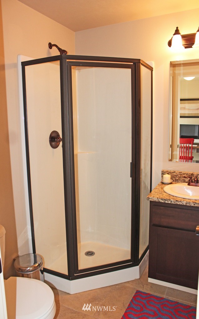 5020 Delridge Way Southwest, Unit A Seattle, WA 98106 - Photo 19 of 22 a bathroom with a granite countertop sink and a mirror