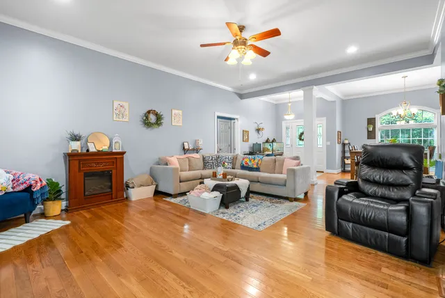 a living room with furniture a fireplace and a chandelier