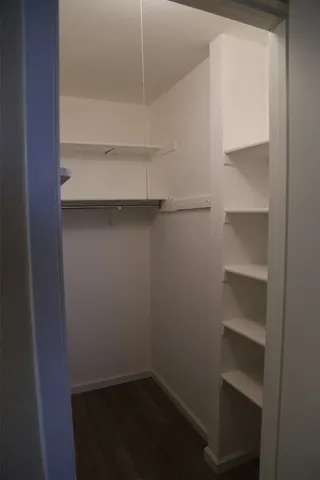 a view of walk in closet with empty racks