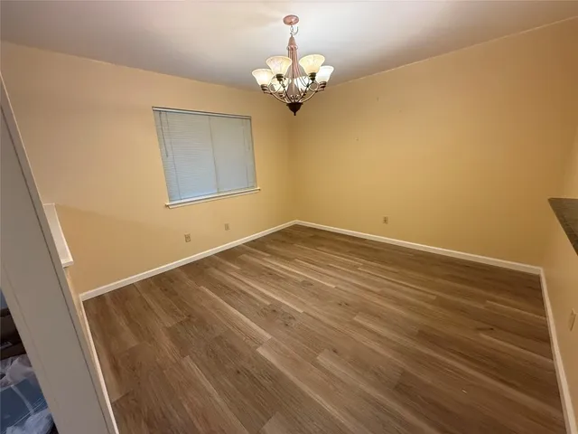 a view of a room with wooden floor and chandelier