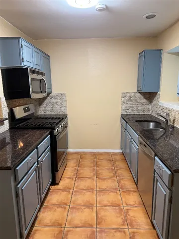 a kitchen with a sink a stove top oven and cabinets