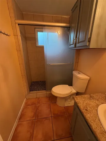a bathroom with a granite countertop toilet and a sink