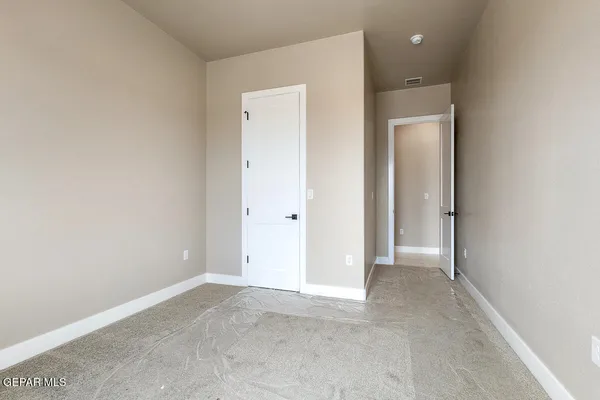 an empty room with closet and a bathroom