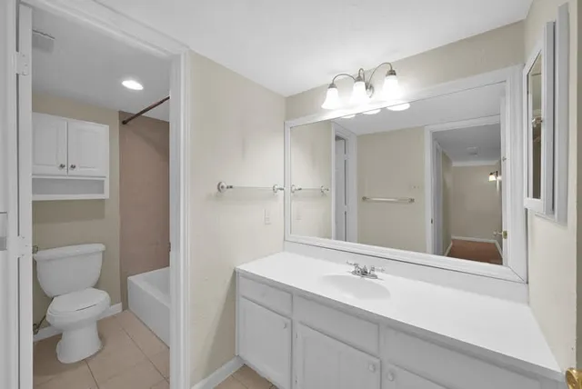 a bathroom with a granite countertop sink toilet a large mirror and shower