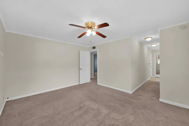 a view of a room with a ceiling fan and window