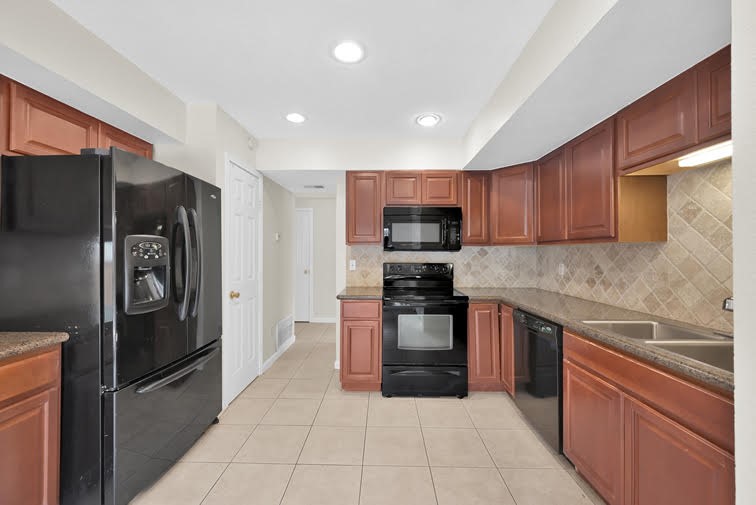 10902 Auger Place Spring, TX 77380 - Photo 8 of 21 a kitchen with stainless steel appliances granite countertop a refrigerator and a sink