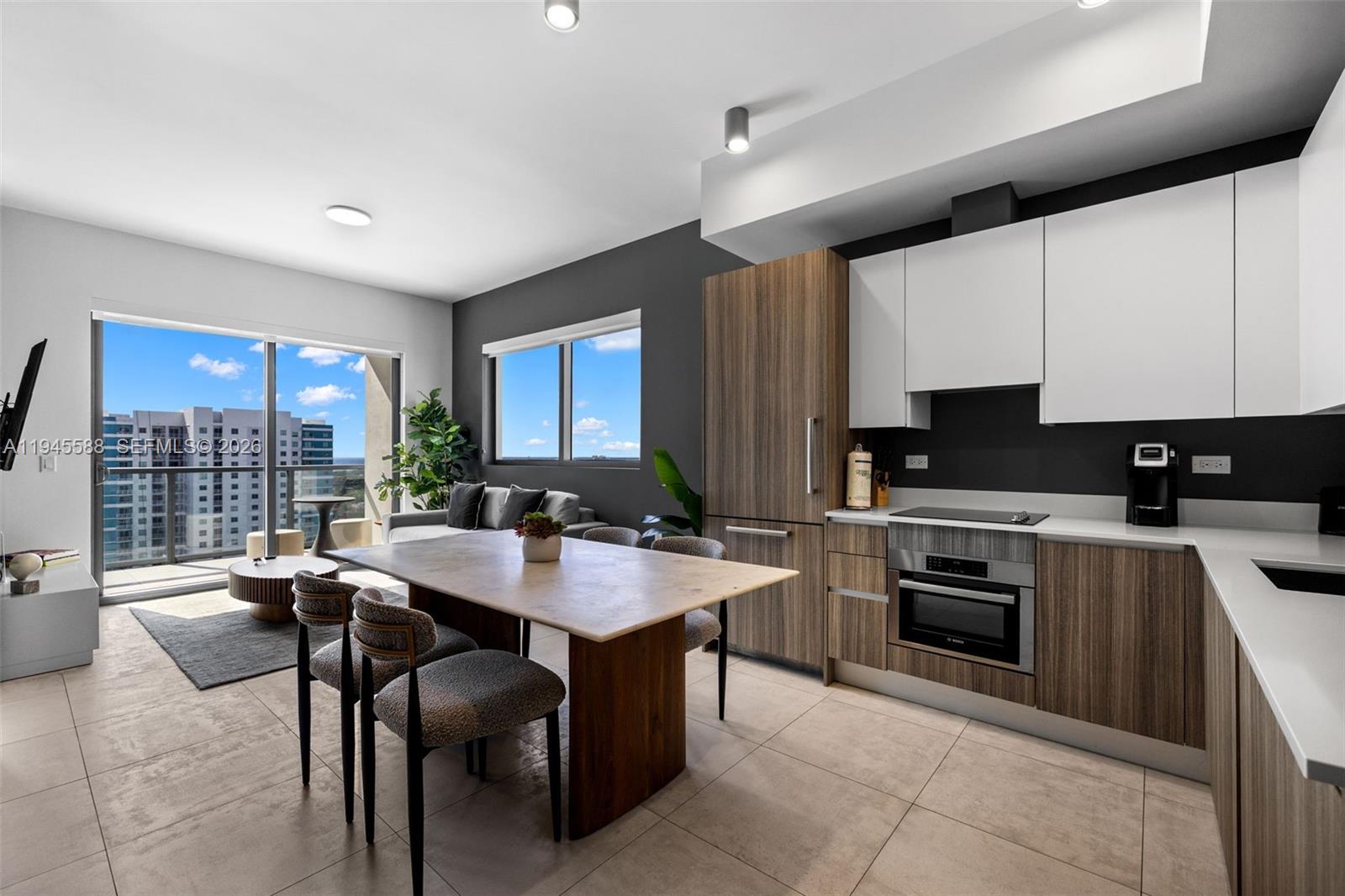 239 Southwest 9th Street, Unit 2102 Miami, FL 33130 - Photo 2 of 35 a open kitchen with stainless steel appliances granite countertop a stove top oven a sink dishwasher a dining table and chairs with wooden floor