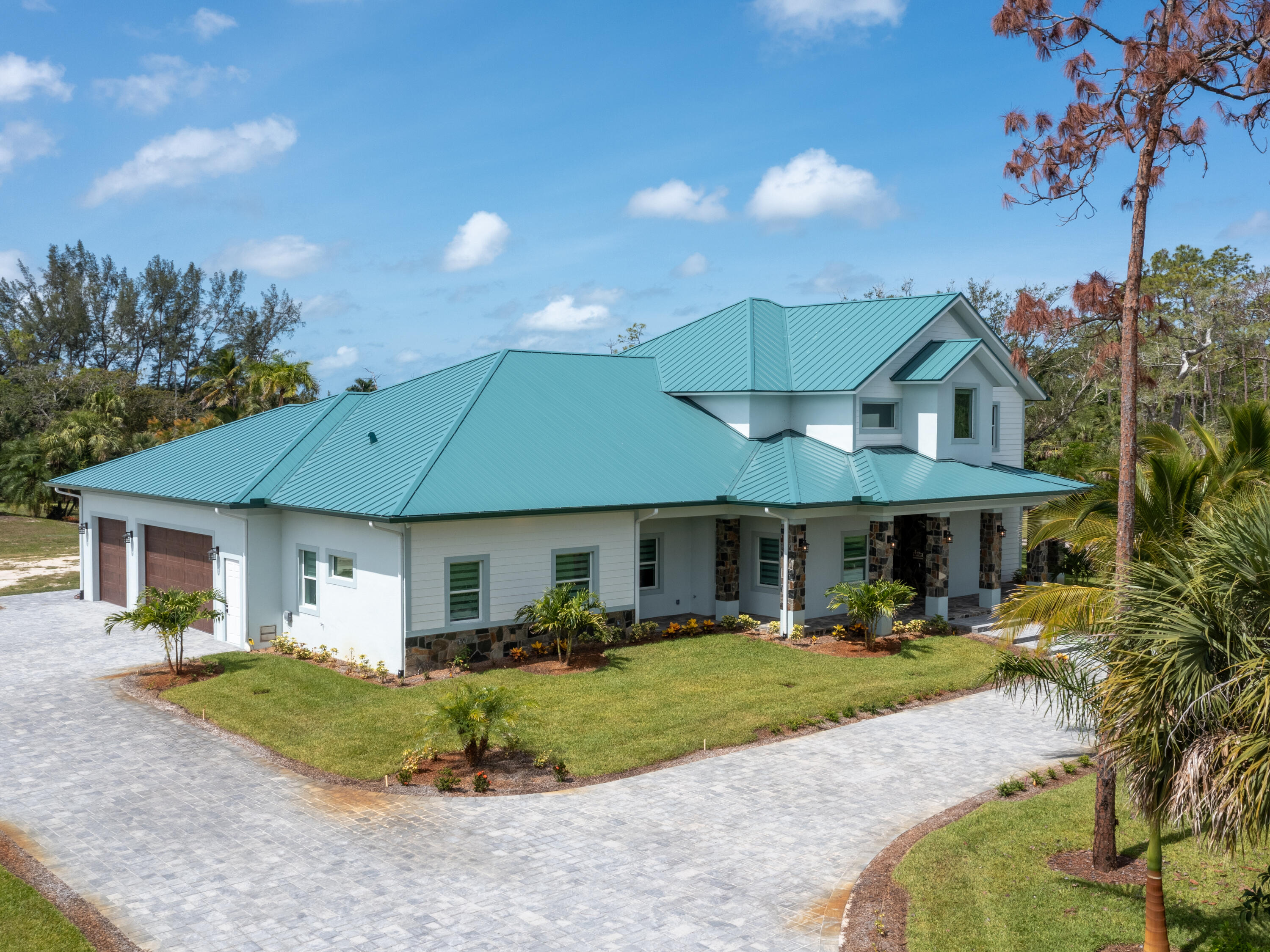 256 Price Street Naples, FL 34113 - Photo 12 of 42 a front view of a house with a yard table and chairs